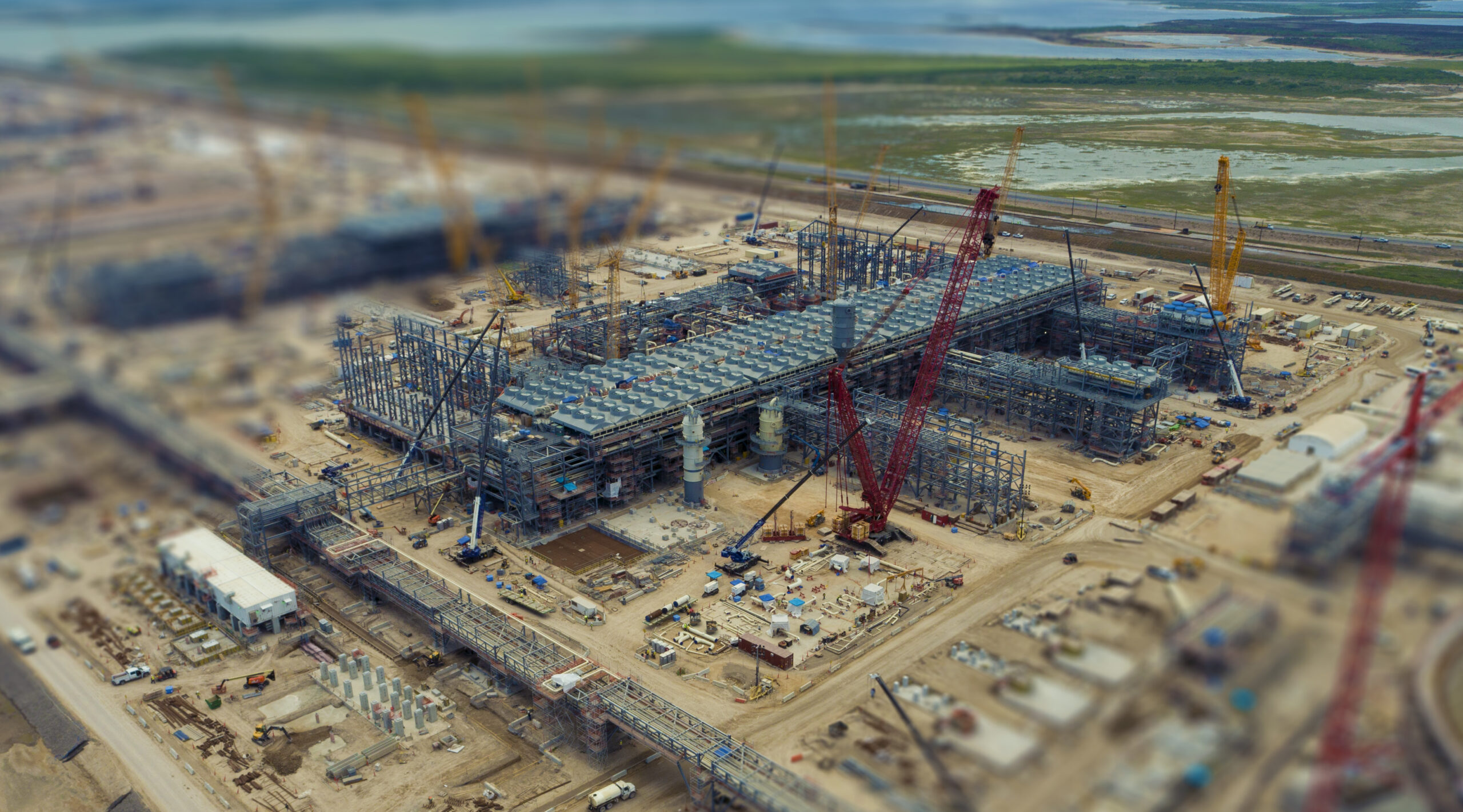 NextDecade's RGLNG terminal under construction with massive red and yellow cranes spread out across the large site