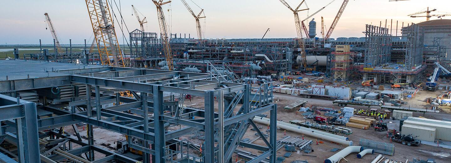 Phase 1 of the RGLNG facility under construction with large yellow cranes surrounding large steel frames