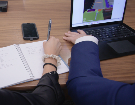 A close up on NextDecade employee hands looking over a data sheet on a conference table
