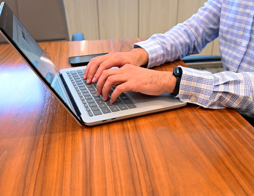 A close up of a NextDecade employee working on a laptop