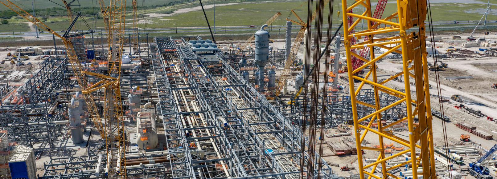 NextDecade's RGLNG terminal under construction with the coast and distant chemical refineries in the background