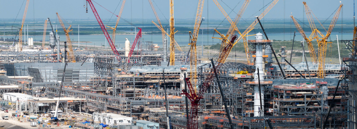 Phase 1 of the RGLNG facility under construction with large yellow cranes surrounding large steel frames