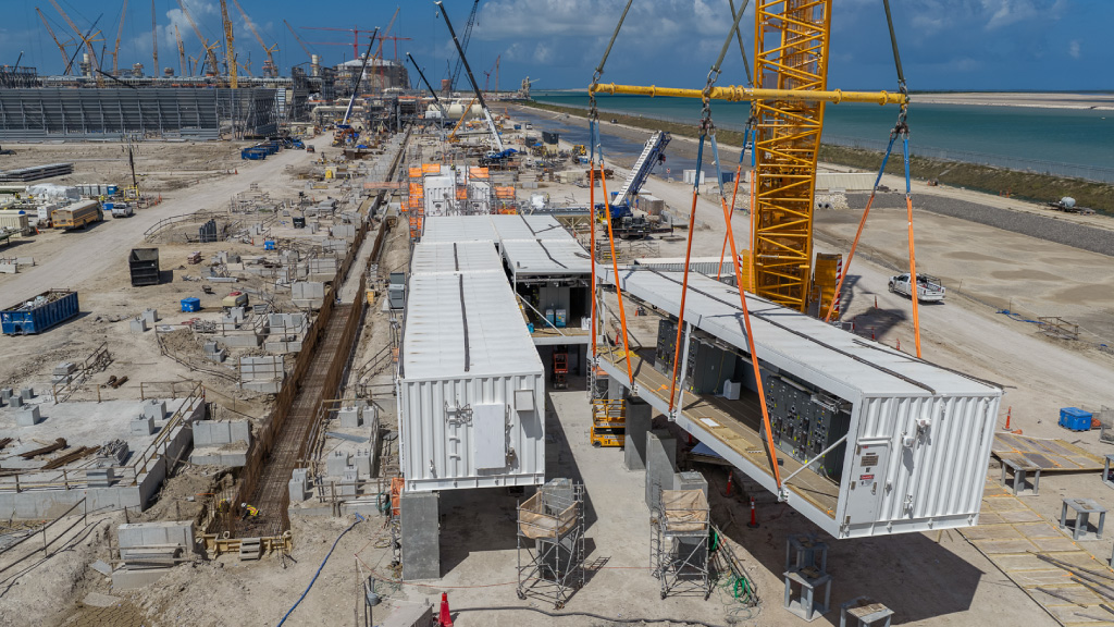 Equipment contained in a cargo container being lifted into place by a crane